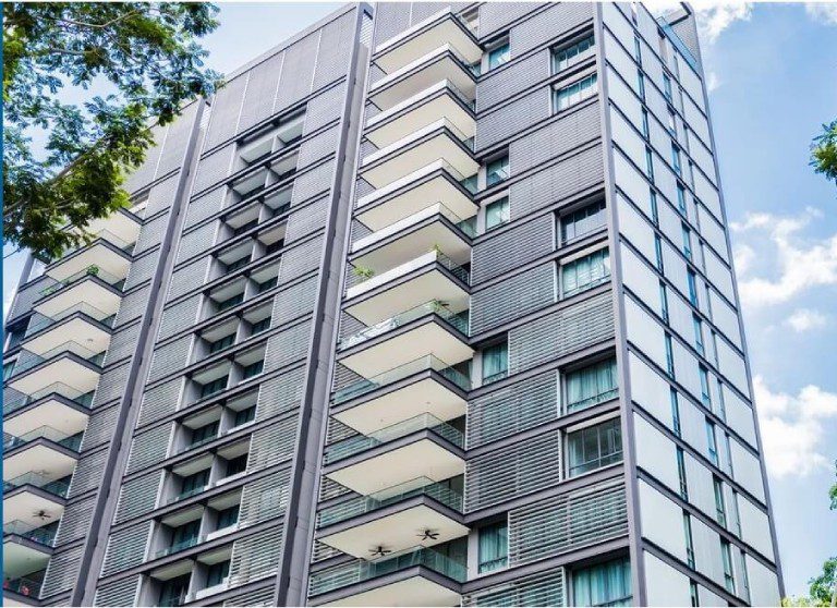 A tall building with many balconies on the side.